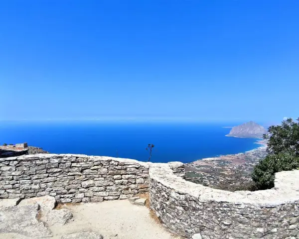 Vista mozzafiato dal castello di Erice, con il mare blu intenso e il Monte Cofano all'orizzonte. Un luogo magico da esplorare.