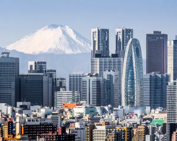 Skyline di grattacieli moderni con il Monte Fuji innevato sullo sfondo, un panorama iconico della citta piu popolata al mondo.
