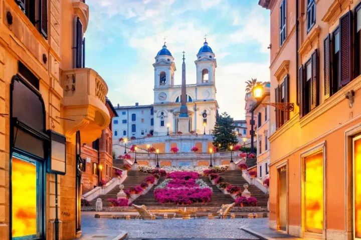 Scalinata di Trinità dei Monti a Roma, un luogo iconico per i tuoi prossimi viaggi da fare, con fiori colorati e un'atmosfera magica.
