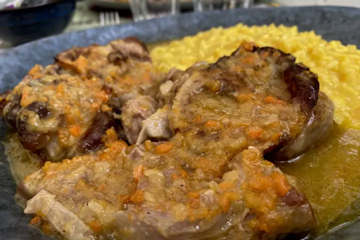 Un piatto di ossobuco con risotto alla milanese, un classico da provare per scoprire cosa mangiare a Milano.
