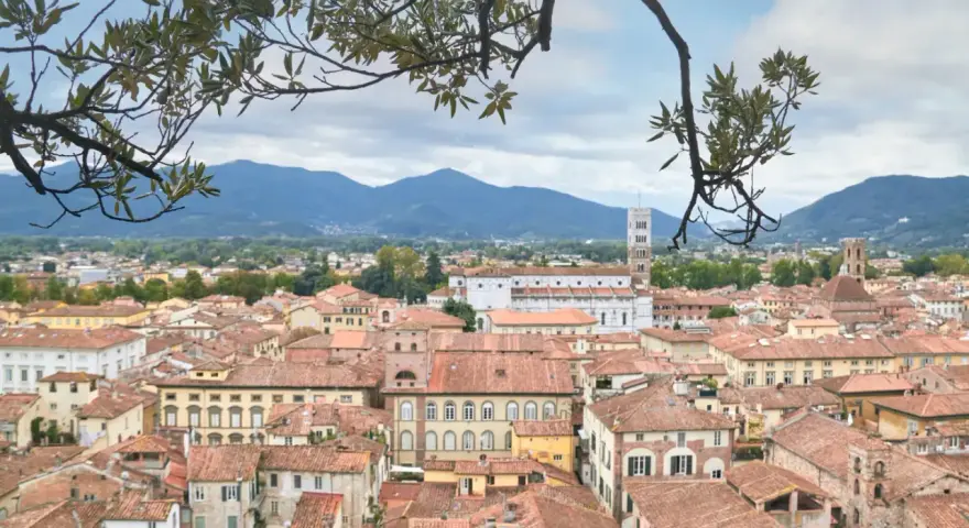 Panoramica di Lucca con tetti rossi e montagne sullo sfondo. Perfetto per scoprire cosa vedere in un giorno.