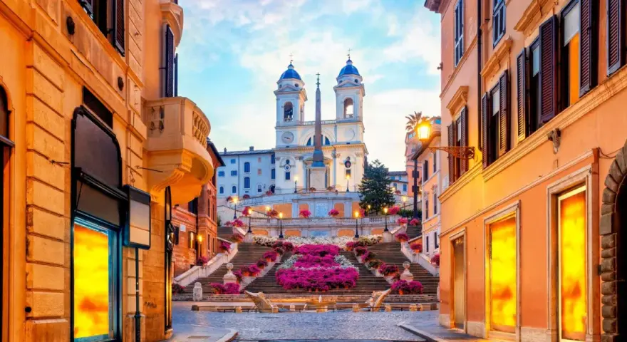 Scalinata di Trinità dei Monti a Roma, un luogo iconico per i tuoi prossimi viaggi da fare, con fiori colorati e un'atmosfera magica.