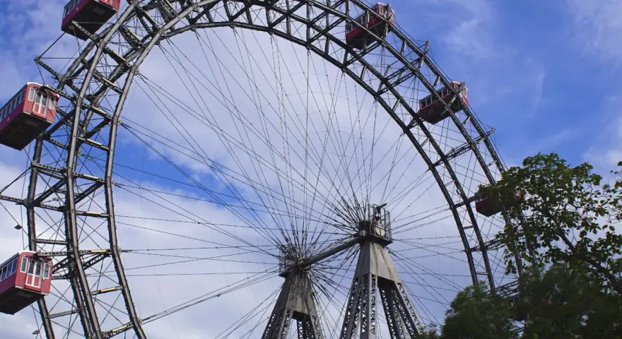 La Ruota Panoramica di Vienna, un'icona per chi cerca cosa vedere a Vienna in 1 giorno, con le sue cabine rosse sotto un cielo azzurro.