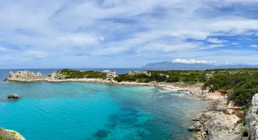 Acque cristalline e rocce scolpite dal vento sull'isola di Pianosa, un paradiso naturale incontaminato.