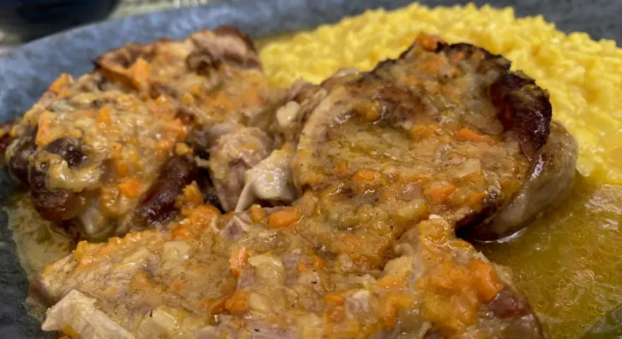 Un piatto di ossobuco con risotto alla milanese, un classico da provare per scoprire cosa mangiare a Milano.