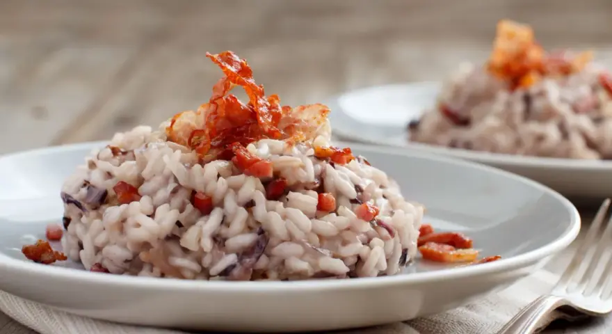 Risotto cremoso con radicchio e croccante guanciale, un'ottima idea su cosa mangiare a Treviso.