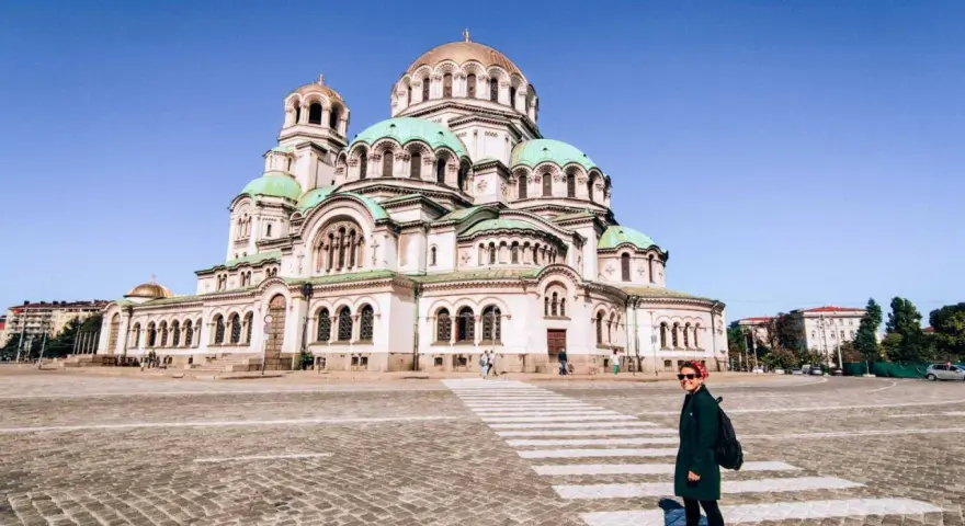 Una donna attraversa la strada davanti alla maestosa Cattedrale Alexander Nevsky, un'icona di cosa fare a Sofia.