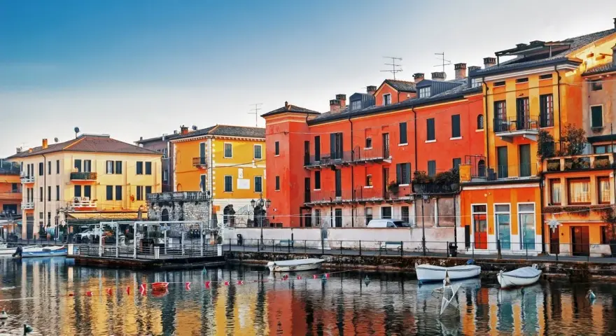 Colorate case affacciate sull'acqua, un incantevole scorcio di una delle tante città da visitare nel nord Italia.