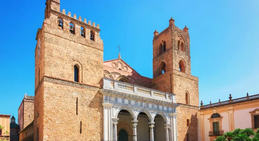 Monreale: cosa vedere? L'imponente Duomo con le sue torri campanarie domina la piazza, un capolavoro normanno da non perdere.