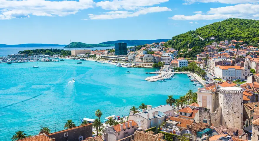 Splendido panorama di Spalato: cosa vedere nel porto turistico, la città con i suoi edifici storici e la collina verdeggiante.