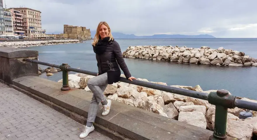 Donna sorridente si gode il panorama di Castel dell'Ovo e del mare, un assaggio di Napoli in 3 giorni.