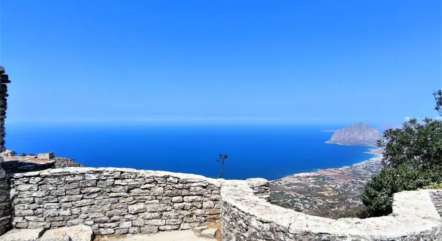 Vista mozzafiato dal castello di Erice, con il mare blu intenso e il Monte Cofano all'orizzonte. Un luogo magico da esplorare.