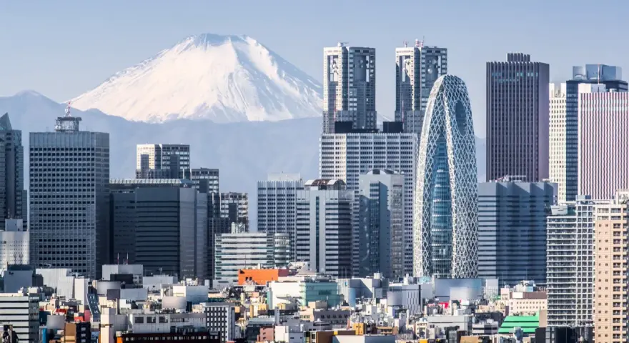Skyline di grattacieli moderni con il Monte Fuji innevato sullo sfondo, un panorama iconico della citta piu popolata al mondo.