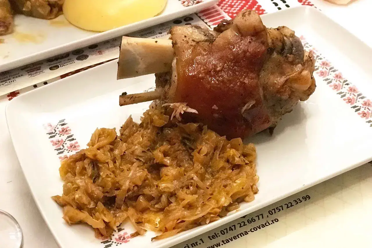 Stinco di maiale arrosto con crauti, un classico da provare per capire cosa mangiare a Bucarest.