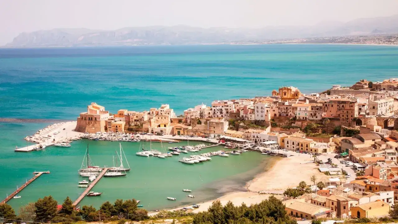 Panoramica di Castellammare del Golfo: cosa vedere nel borgo marinaro con il suo castello, il porto turistico e le case colorate affacciate sul mare turchese.