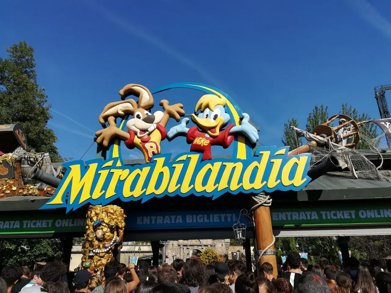Ingresso di Mirabilandia, parco divertimenti in Italia, con personaggi animati e un tesoro piratesco.