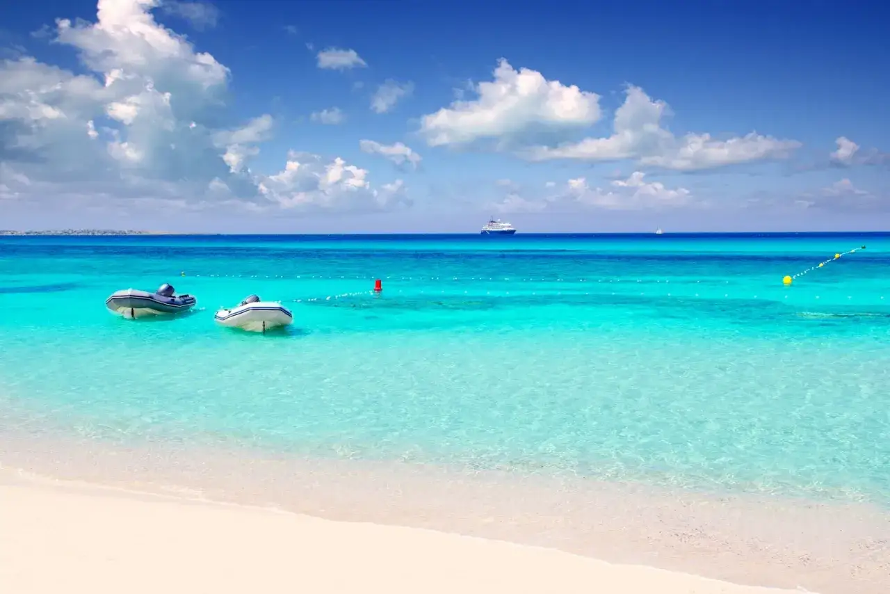 Due gommoni in attesa sulla spiaggia di Formentera, un invito a esplorare le meraviglie marine.