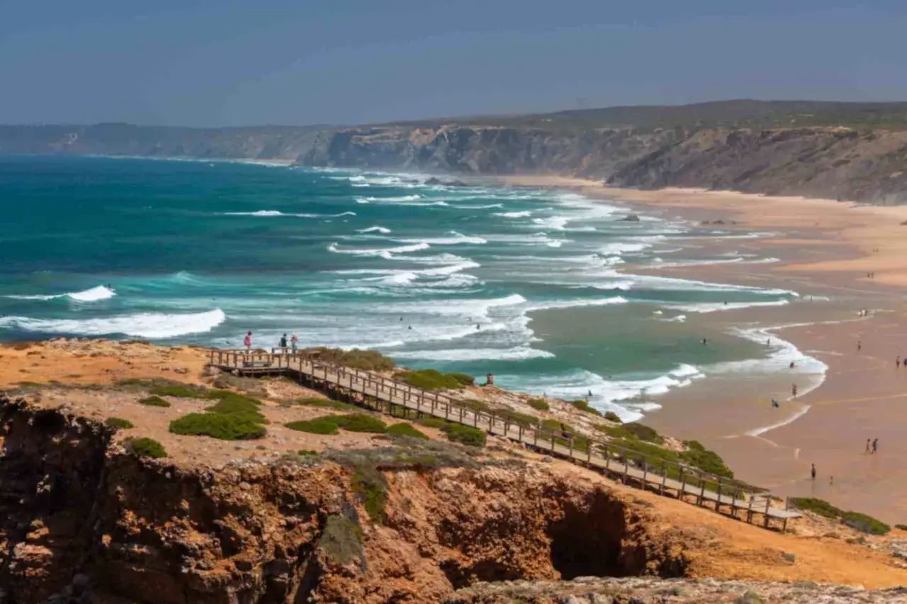 Scogliere rocciose e una spiaggia dorata con onde turchesi. Un luogo perfetto per pensare a dove andare in vacanza ad agosto fuori Europa.