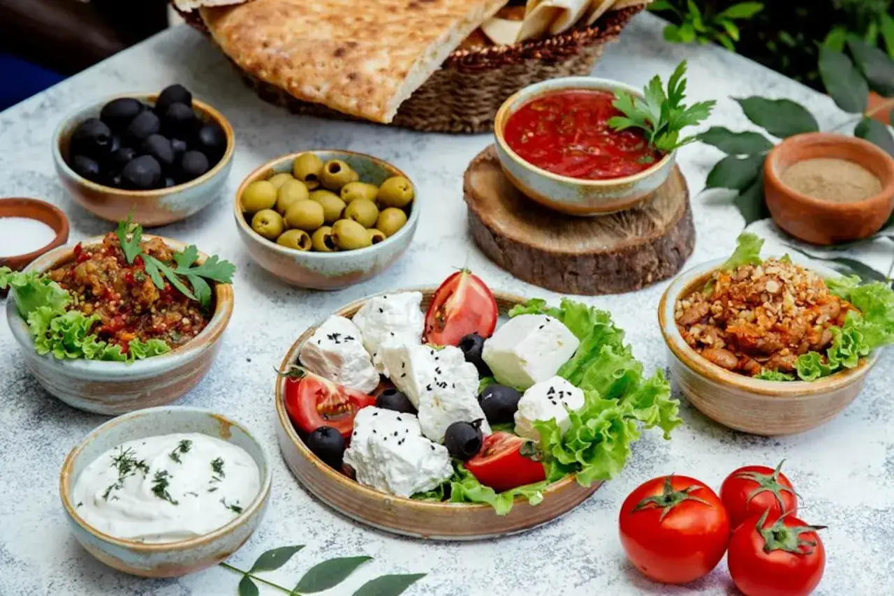 Un assaggio dei piatti tipici grecia: feta, olive, pomodori, salse e pane fresco.