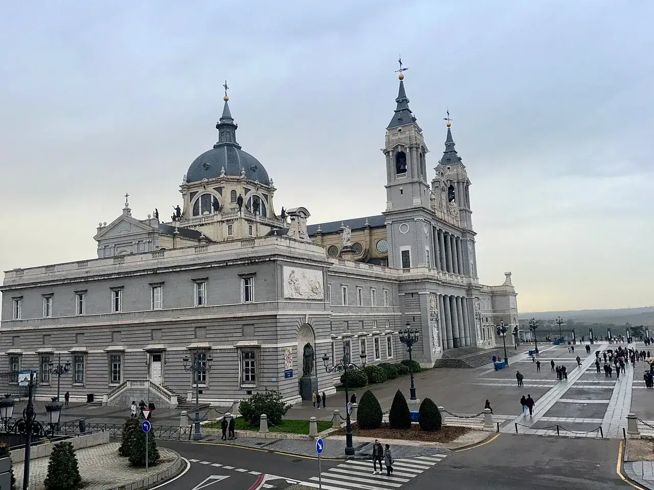La Cattedrale dell'Almudena e la piazza antistante, un luogo imperdibile tra le cose da fare a Madrid, con gente che passeggia.