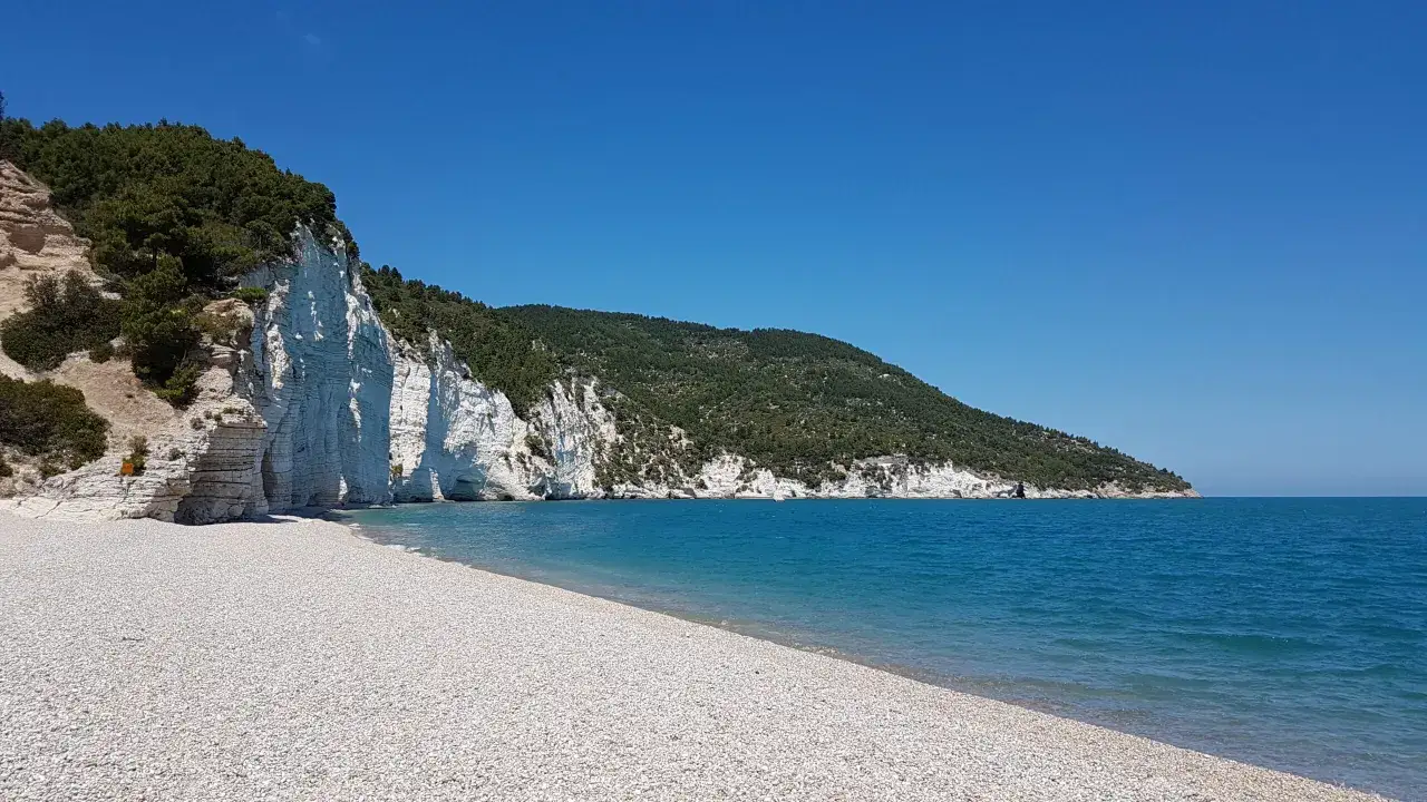 Scogliera bianca a picco sul mare turchese, una delle 10 spiagge pi&ugrave; belle del Salento.