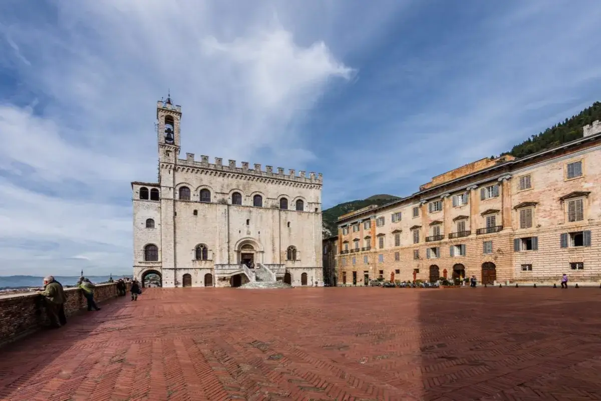 Piazza Grande a Gubbio, con il Palazzo dei Consoli e altri edifici storici. Perfetto per scoprire cosa vedere a Gubbio in un giorno.