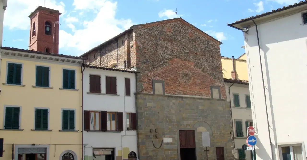 Un antico borgo a Buggiano, con una torre campanaria in mattoni rossi e facciate di case colorate e in pietra.