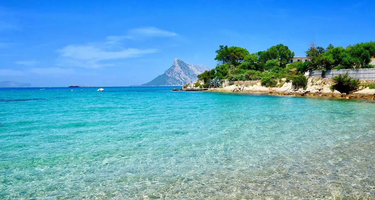 Acque cristalline e una vista mozzafiato su un'isola montuosa: un luogo perfetto dove andare in vacanza a giugno per godersi il mare.