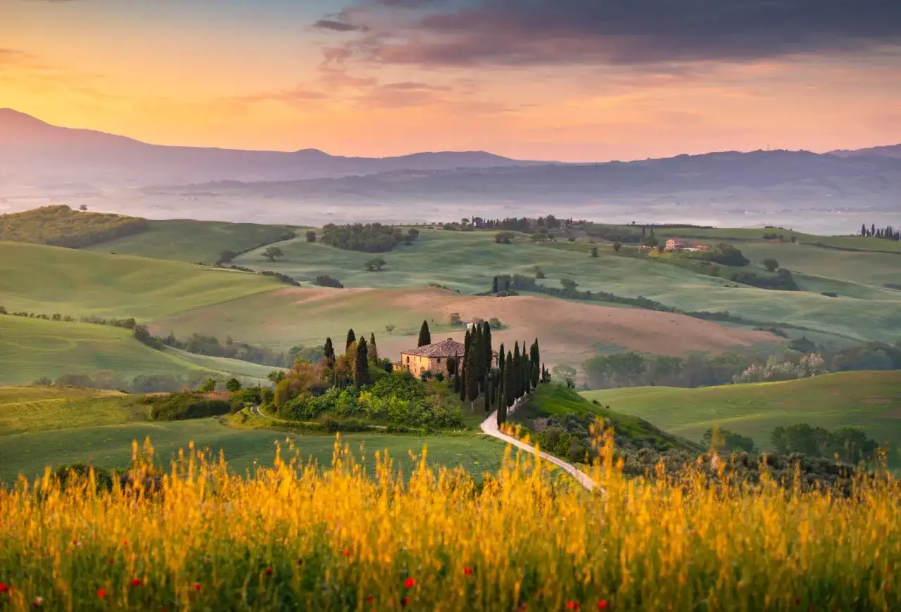 Dolce panorama toscano con casale e cipressi, ideale per scoprire cosa vedere a Siena e dintorni in 3 giorni.
