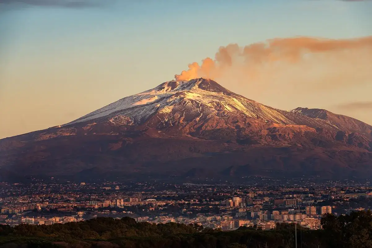 Etna fumante domina la città, un'immagine perfetta per scoprire cosa vedere a Catania e dintorni in 3 giorni.