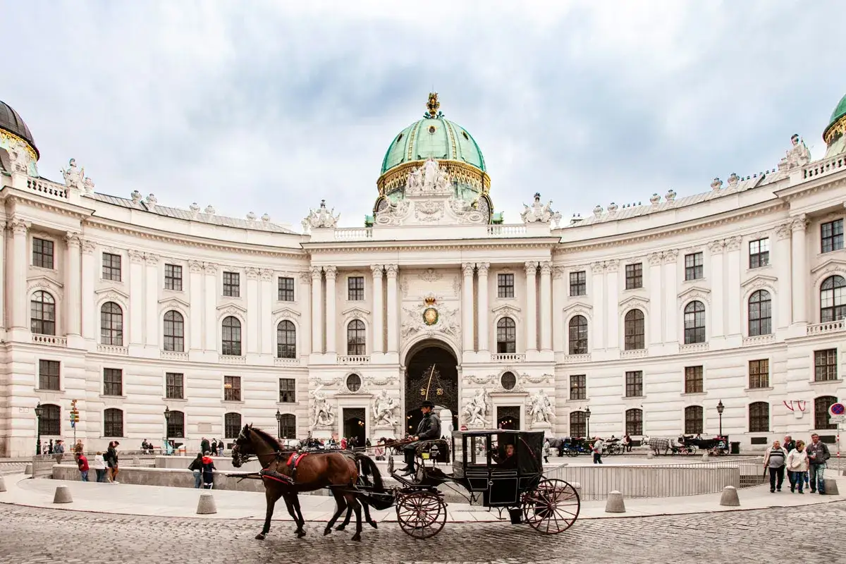 Carrozza trainata da cavalli davanti al Palazzo Imperiale Hofburg, un'idea per cosa vedere a Vienna in 3 giorni.