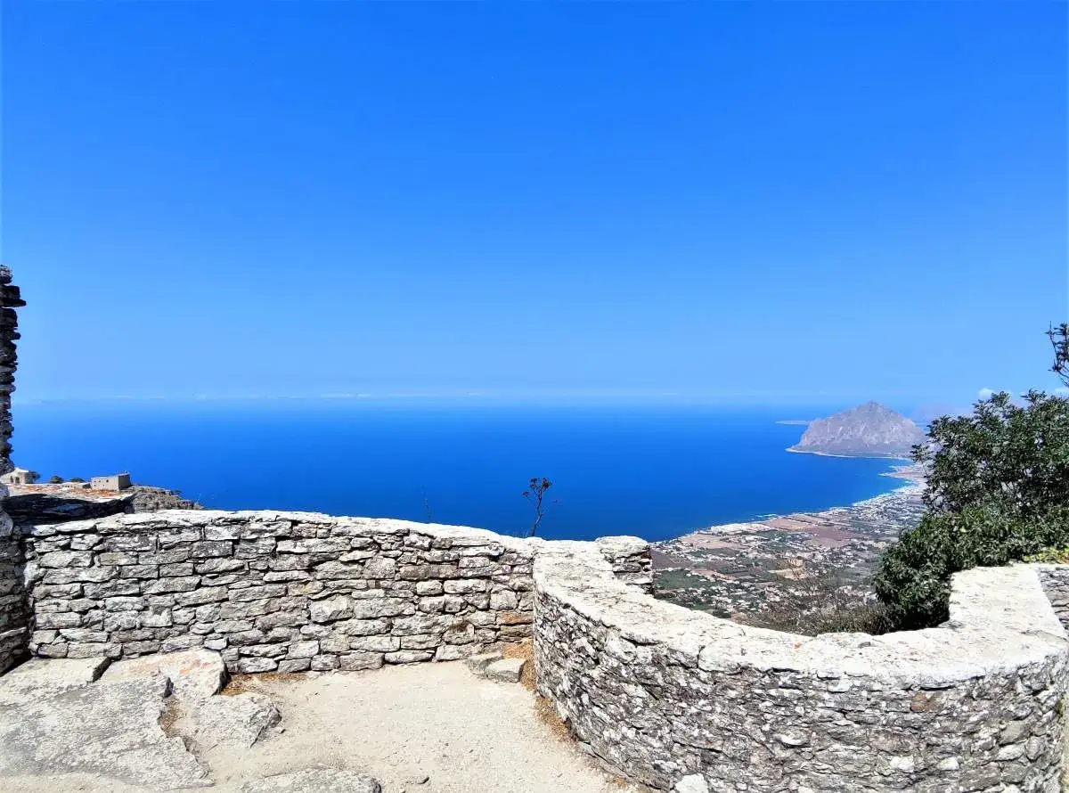 Vista mozzafiato dal castello di Erice, con il mare blu intenso e il Monte Cofano all'orizzonte. Un luogo magico da esplorare.