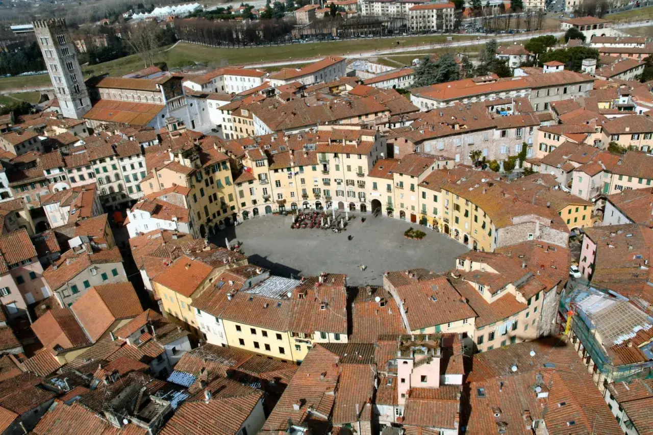 Lucca cosa vedere in un giorno: vista aerea della Piazza dell'Anfiteatro, con i suoi edifici ovali e la torre Guinigi.