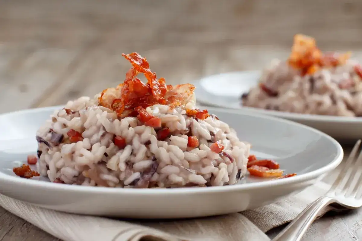 Risotto cremoso con radicchio e pancetta croccante, un classico su cosa mangiare a Treviso.