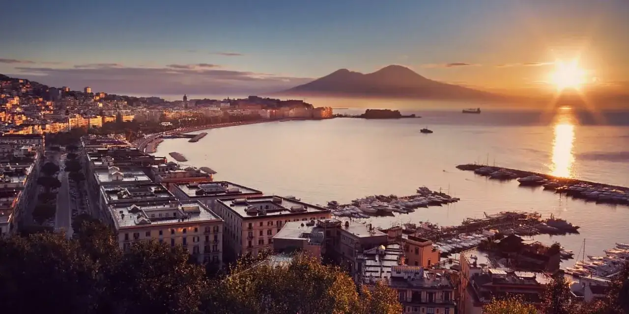 Vista panoramica di Napoli al tramonto, con il Vesuvio sullo sfondo. Perfetto per un itinerario di napoli in 3 giorni.