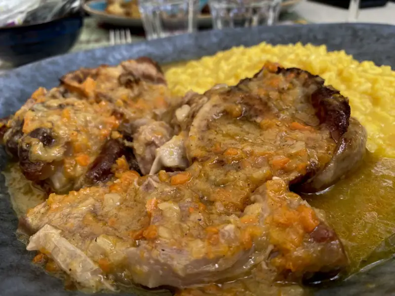 Un piatto di ossobuco con risotto alla milanese, un classico da provare per scoprire cosa mangiare a Milano.