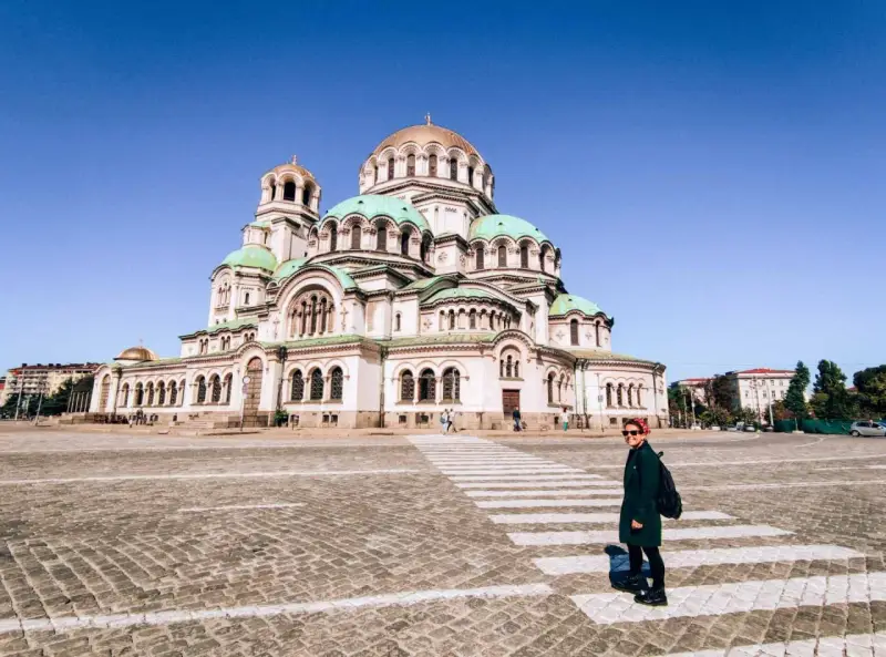 Una donna attraversa la strada davanti alla maestosa Cattedrale Alexander Nevsky, un'icona di cosa fare a Sofia.